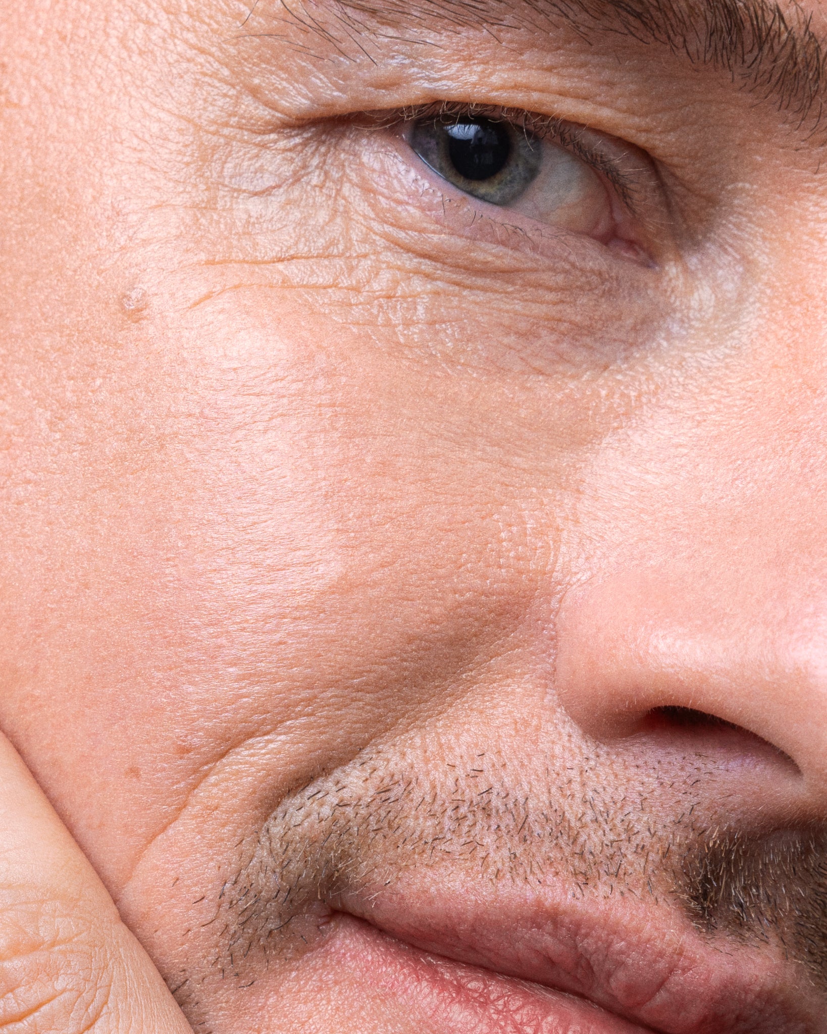 Model wearing MÁDARA Organic Skincare moon flower serum on A3512 serum on skin; close-up portrait shows natural application results.